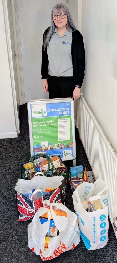 A lady stands with bags of food donations from West Special Fasteners
