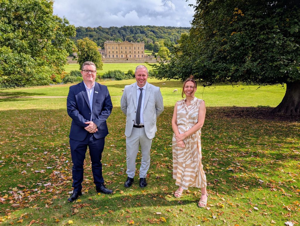 3 employees from West Special Fasteners stand in the grounds of Chatsworth with the house behind them