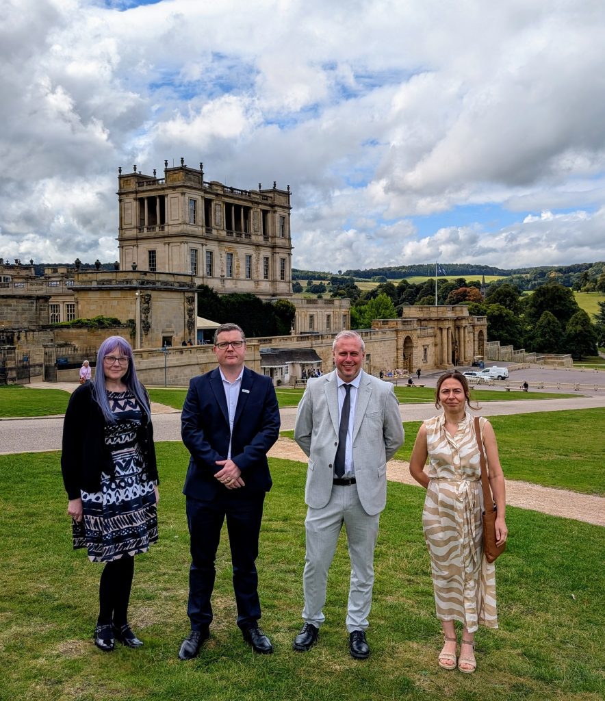 $ employees from Chatsworth stand in the grounds of Chatsworth with the entrance to the gardens behind them