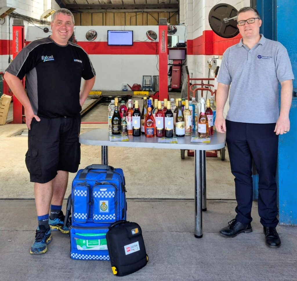 Dronfield Community first responder accepts a donation of bottles from West Special Fasteners